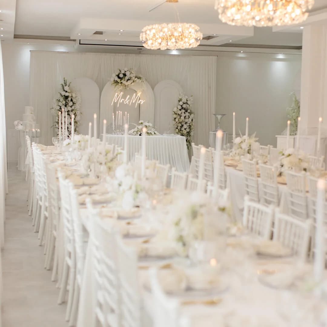 E|S Event Salon mit Kronleuchtern, festlich gedeckten Tischen und Hochzeitskulisse