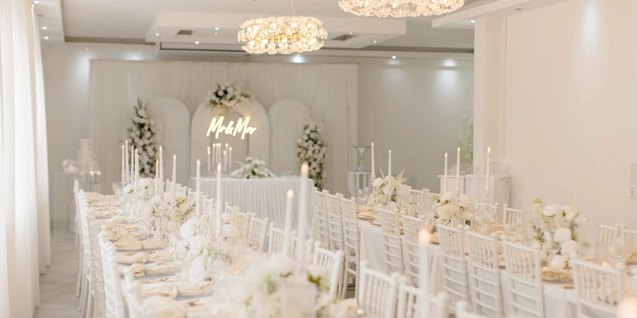 Der E|S Event Salon in Hamm: helle Festtafeln, florale Dekoration und elegante Kronleuchter